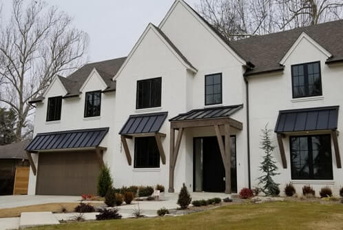 A white house with multiple Standing Seam Roofs